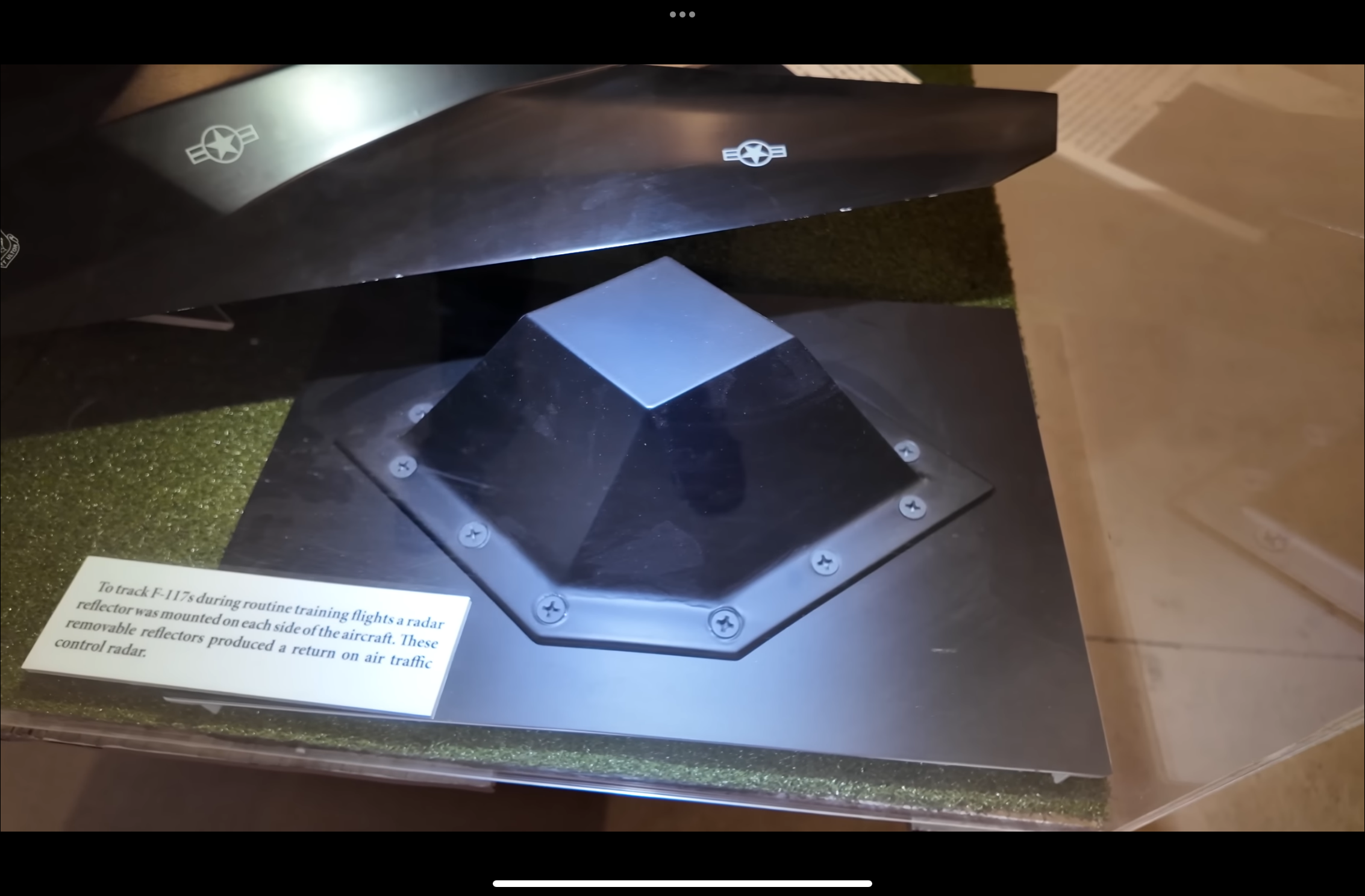 A small removable F-117 radar reflector in a museum display, beside a label explaining its use during training flights.